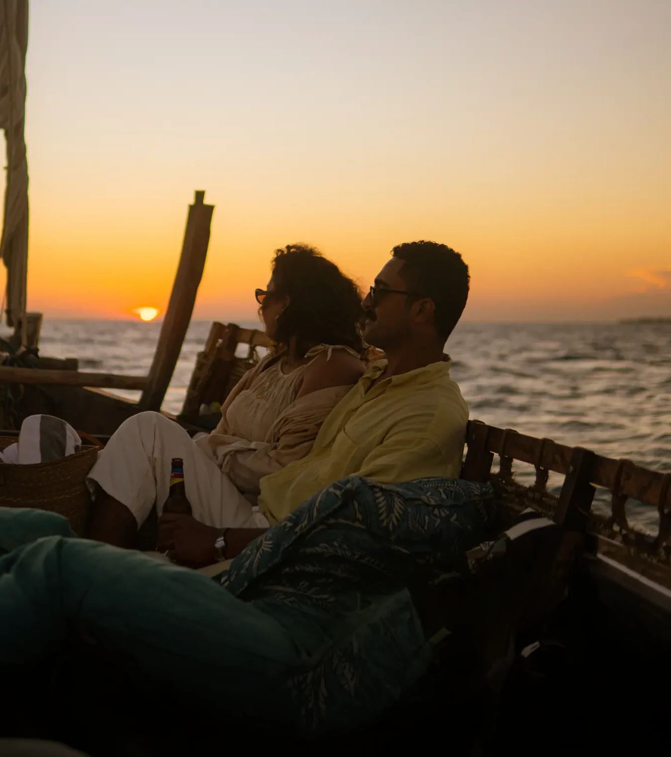 A traditional wooden dhow sailing off Stone Town at golden hour